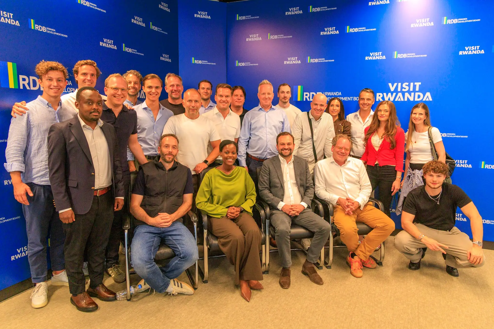 Gruppenfoto der Reisegruppe vor einer Visit-Rwanda-Wand